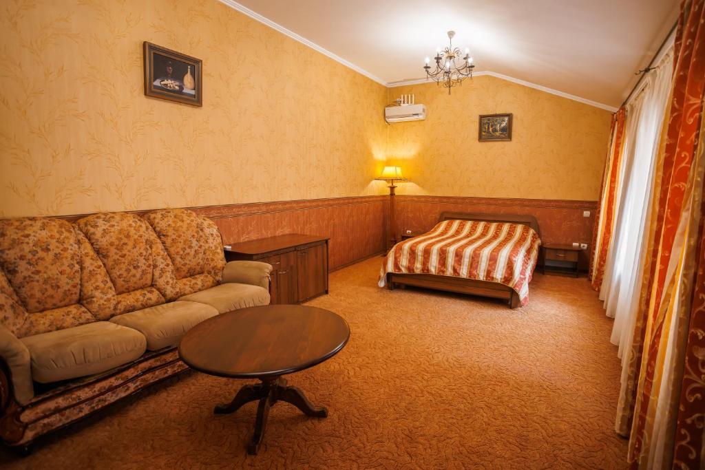 a living room with a couch and a bed at Avenue Hotel in Chernivtsi