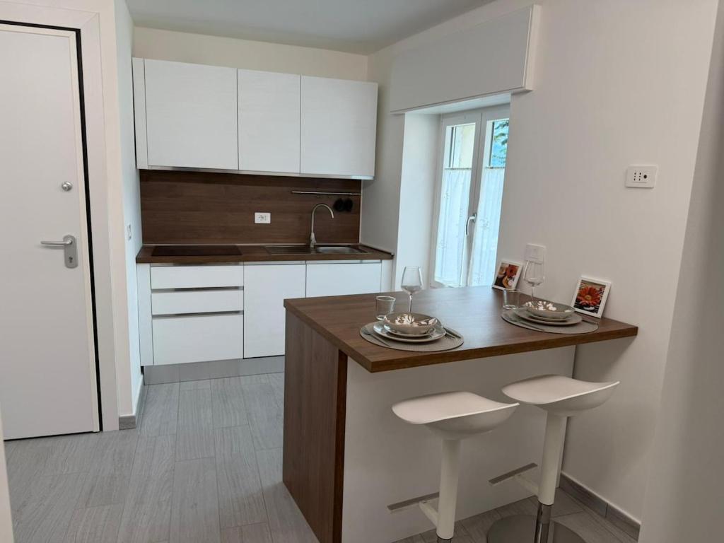 a kitchen with a island with two stools in it at Bellavista-Verceia in Verceia