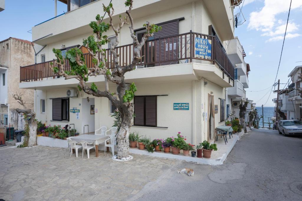 a building with a table and a tree in front of it at Nikos House in Ierapetra