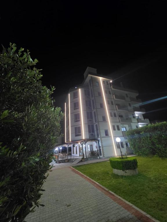 a tall building with a light on it at night at Hotel Restaurant Globi in Velipojë