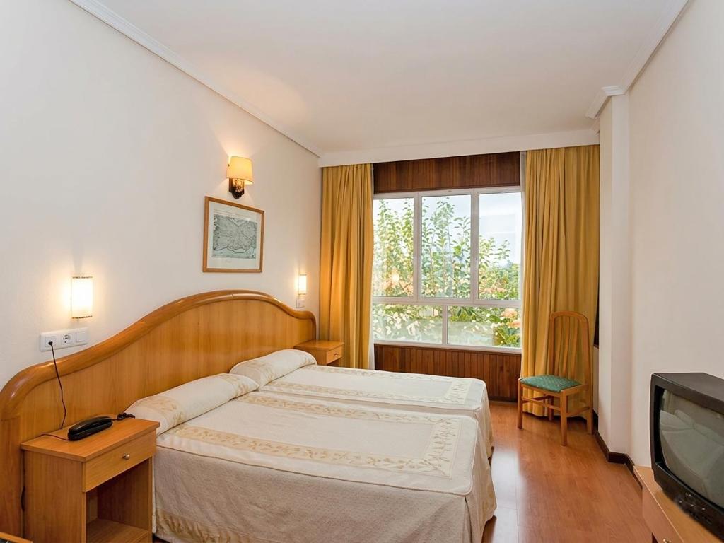 ein Schlafzimmer mit Bett und Fernseher in der Unterkunft Hotel Herbiña 3000 in Cambados