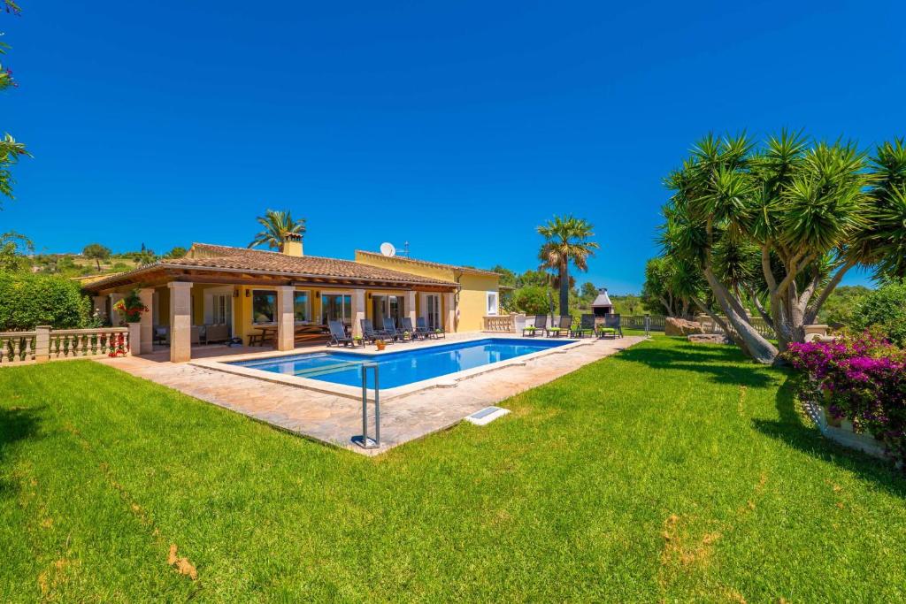 a house with a swimming pool in a yard at Ca na Margalida in Manacor