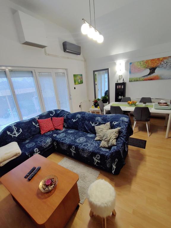 a living room with a blue couch and a table at In the Green in Lopatinec