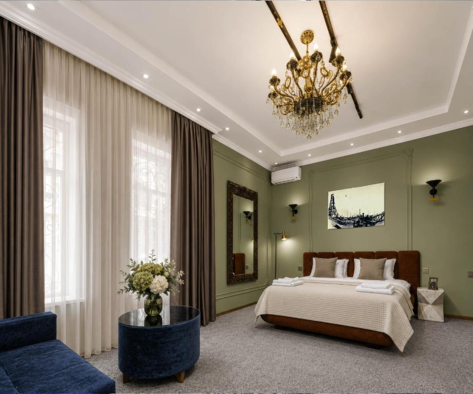a bedroom with a bed and a couch and a chandelier at Old Money Boutique Hotel in Baku