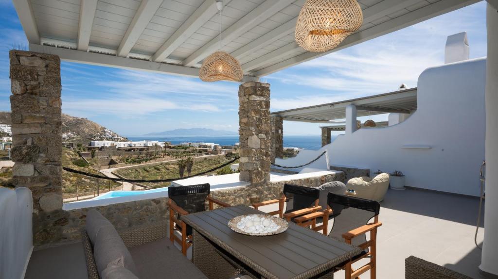 a balcony with a table and chairs and a view of the ocean at Cavo Blue Villas in Elia Beach