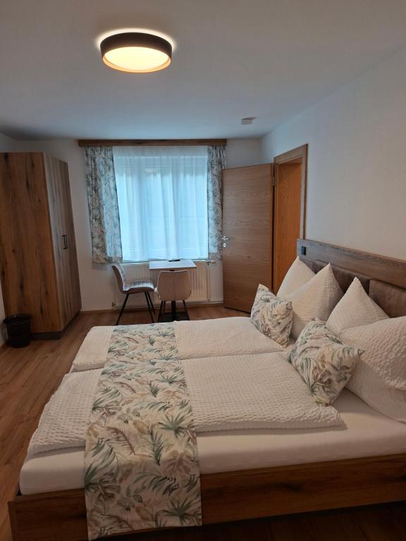 a bedroom with a large bed and a table at Ferienhaus Gebetsberger in Spitz