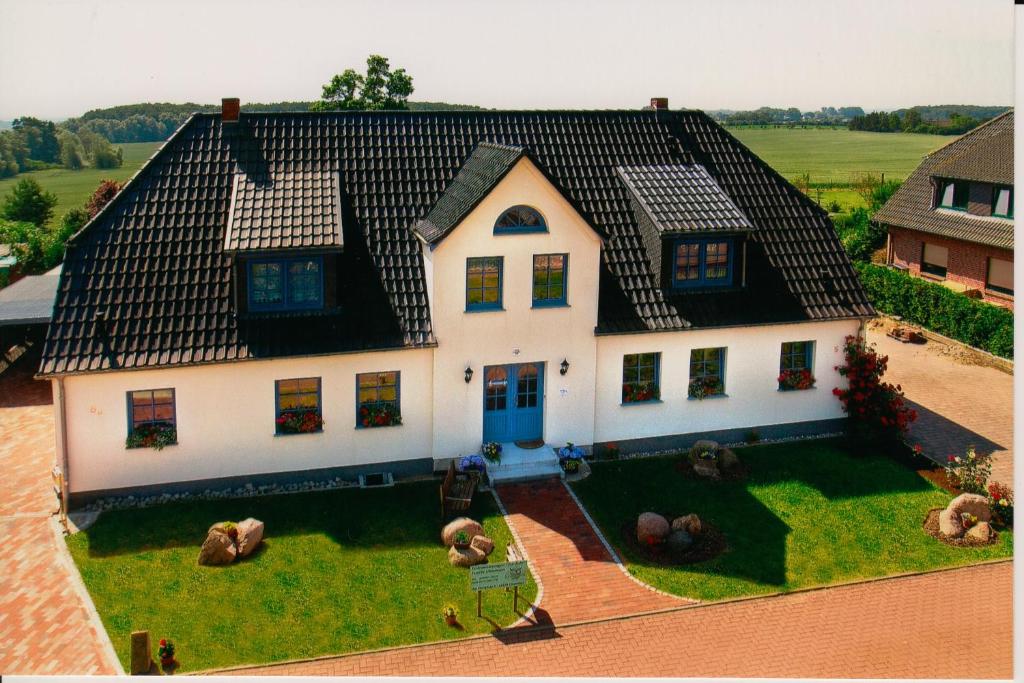 a large white house with a black roof at Ferienwohnungen zur Eule - Steinkauz in Clausdorf