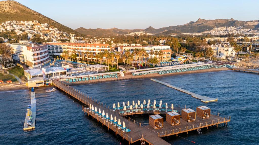 a dock in the water next to a city at Azure By Yelken Hotel in Turgutreis