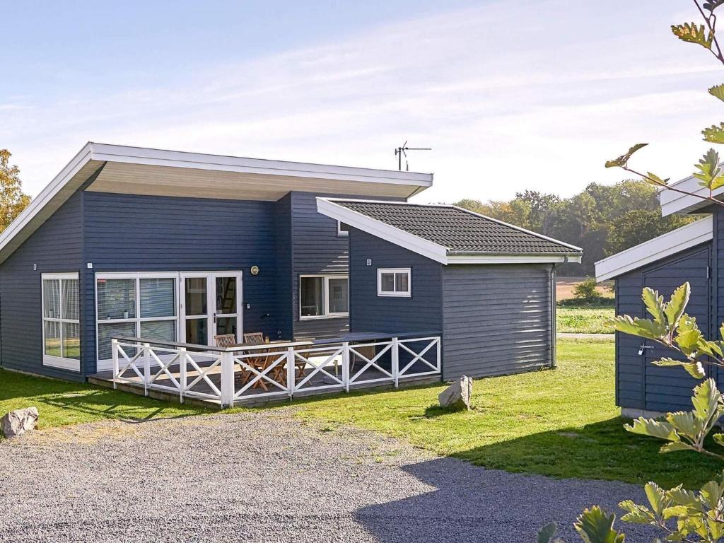 a blue modular home with a porch at Danland Rø Golf Houses in Gudhjem