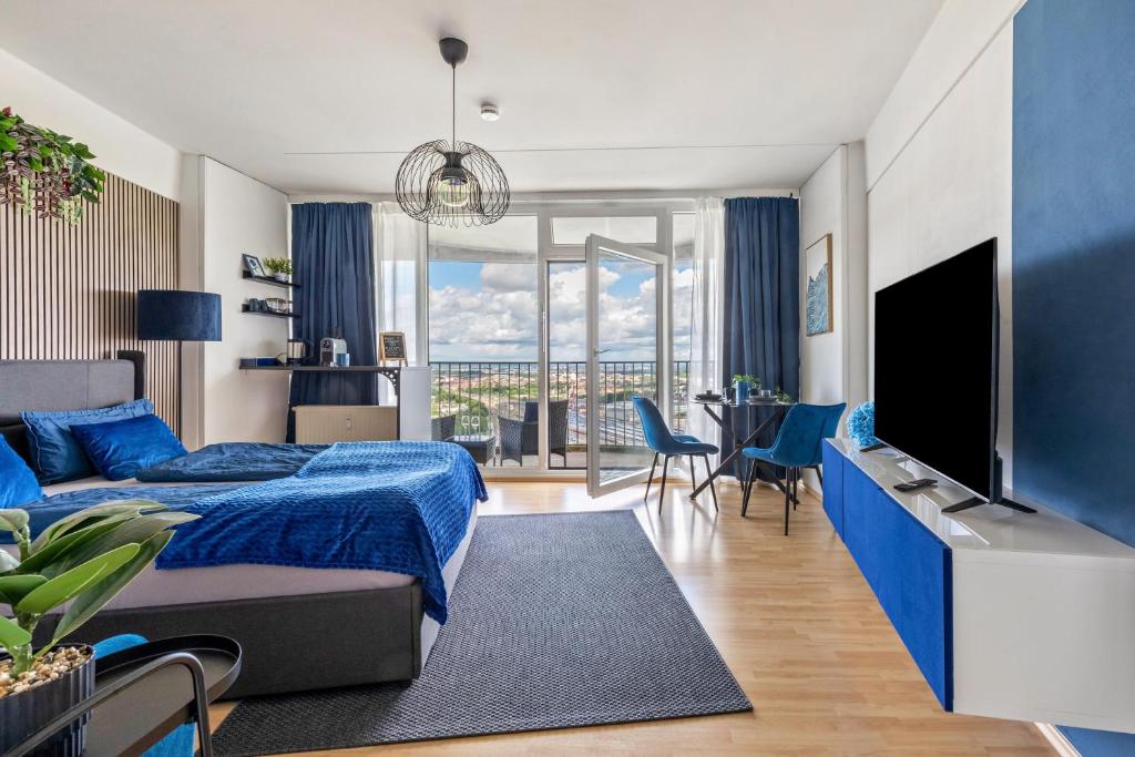 a bedroom with a blue bed and a tv at Global Bnb - Loft 28 Blue in Augsburg
