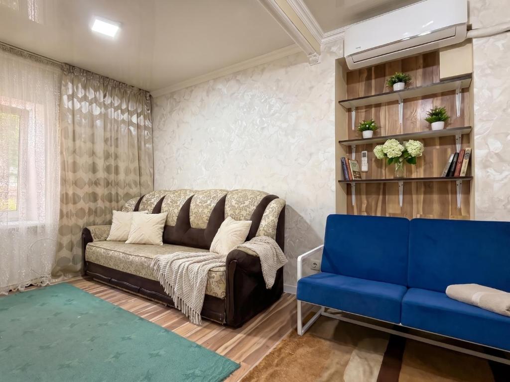 a living room with a couch and a blue chair at 2 Room central in Bălţi
