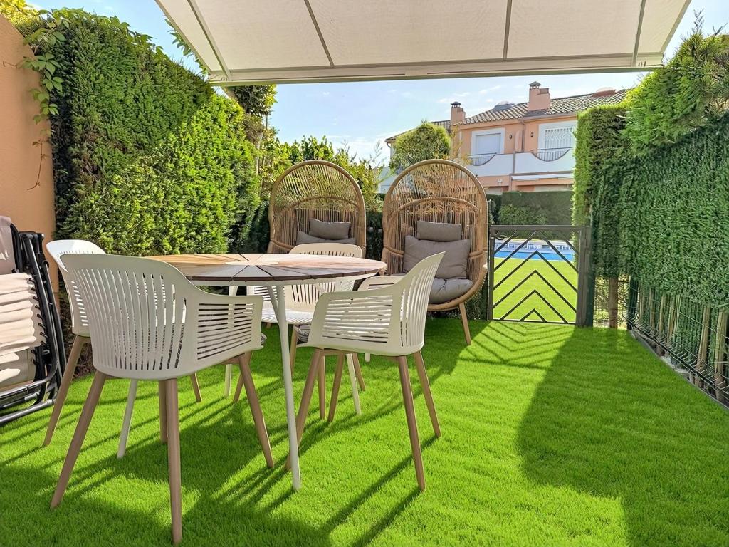a patio with a table and chairs on grass at Mar Blau Estartit Rental in L'Estartit