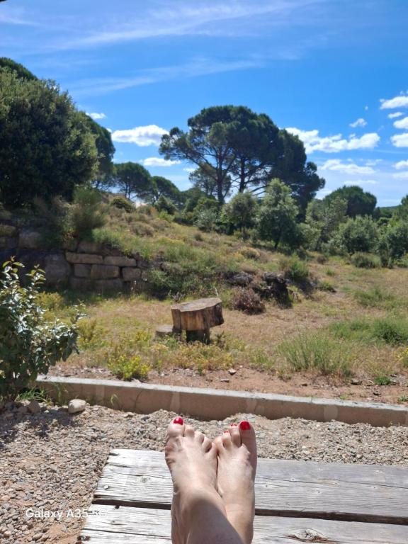 a person with their feet up on a wooden bench at GITE Mourèzeva in Mourèze