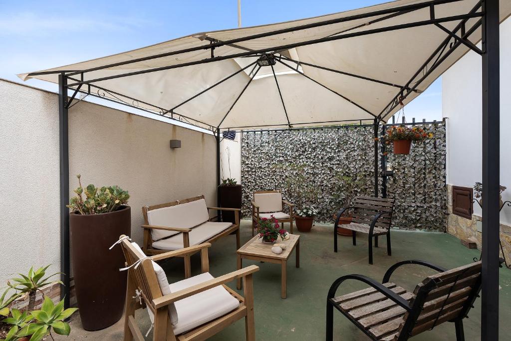 a patio with chairs and tables and a canopy at Demetra Malophoros in Marinella di Selinunte