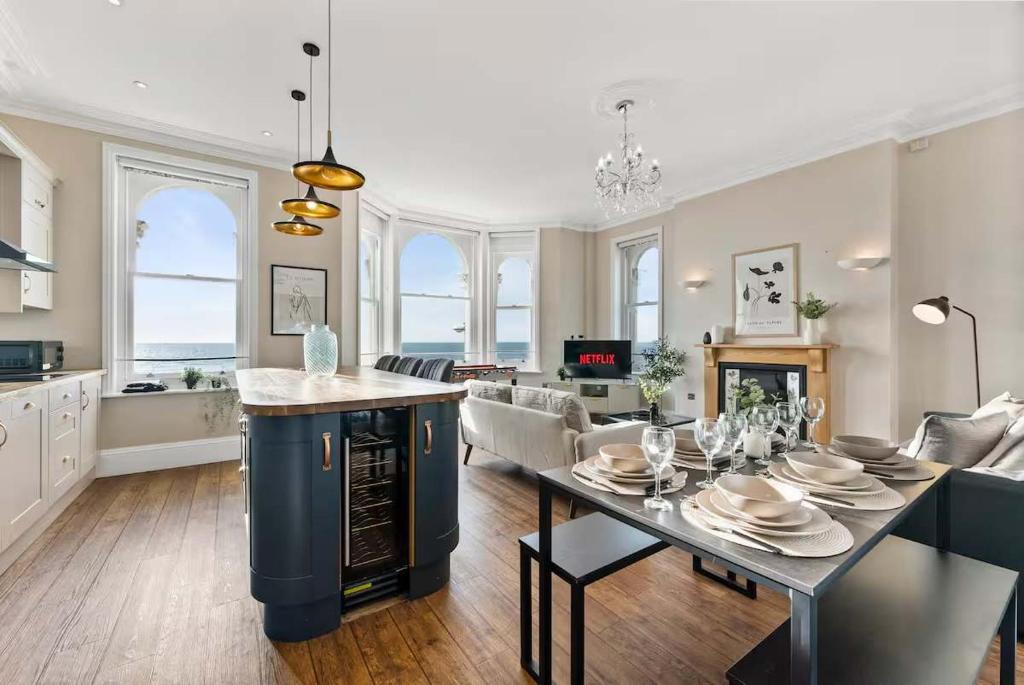 a large kitchen and living room with a dining table at Seafront Duplex Worthing Beach - Sea Views 8 Guests in Worthing