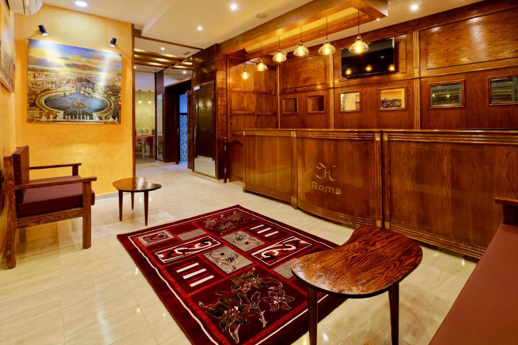 a room with a bar with a stool and a table at Hotel Roma in Tunis