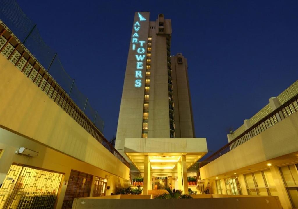 a large building with a sign on it at night at Avari Towers Karachi in Karachi