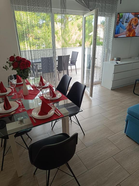 a dining room with a table with red napkins on it at Apartment Domagoj, Novalja,with 3 air conditioning units in Novalja