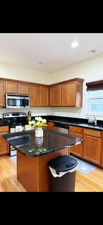 a kitchen with a center island with a vase of flowers at Joykip's place in West Des Moines
