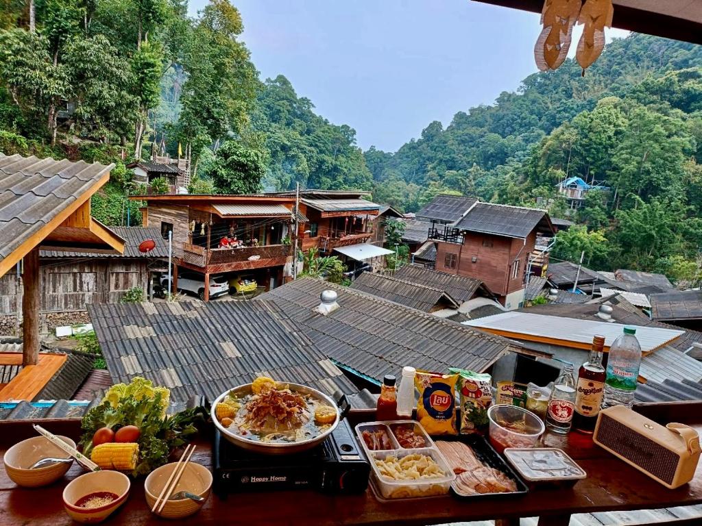 a table with plates of food on top of a village at กินลมชมจันทร์ แม่กำปอง in Ban Pok Nai