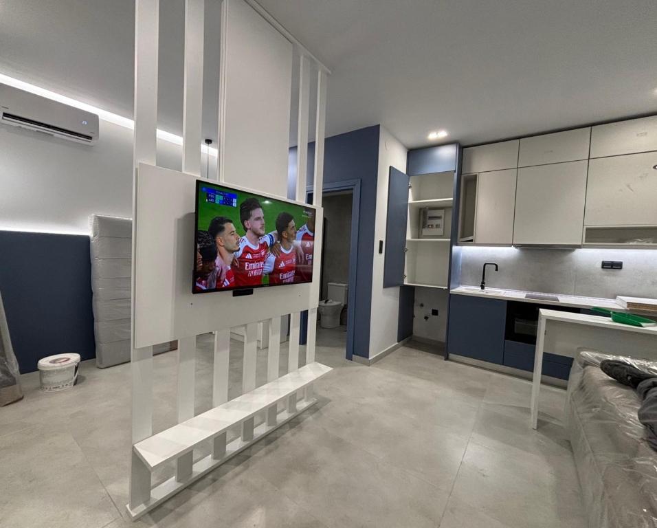 a living room with a tv on a wall at Angelica Suites Keramoti Area in Keramoti