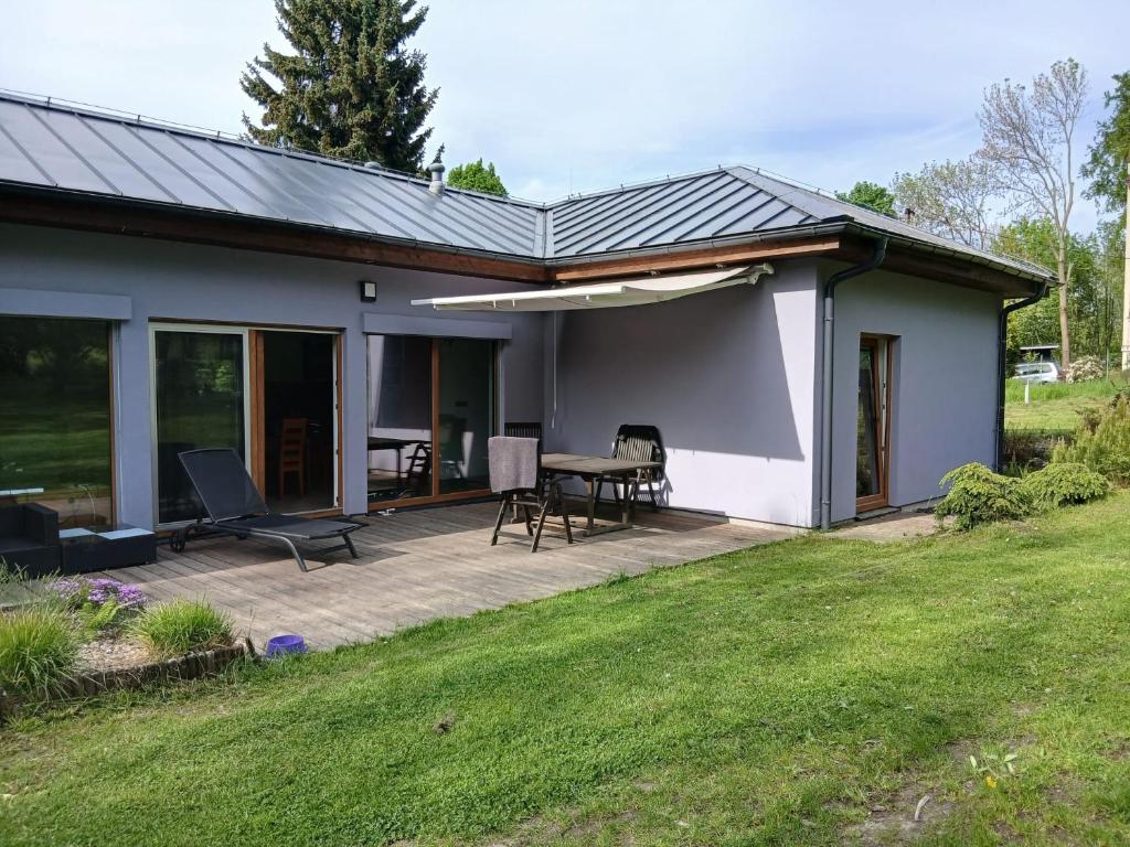 a house with a patio with a table and chairs at Bungalov v Krásné Lípě in Krásná Lípa