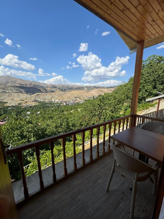 a wooden porch with a table and a bench on it at Ertunç Turizm in Kahramanmaraş