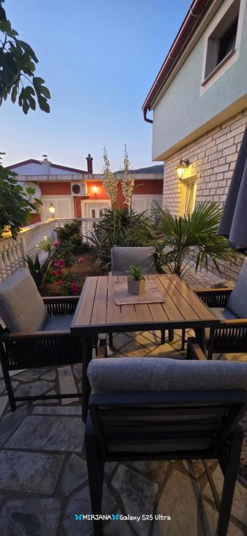 a wooden table and chairs on a patio at Studio Apartman DORA in Senj