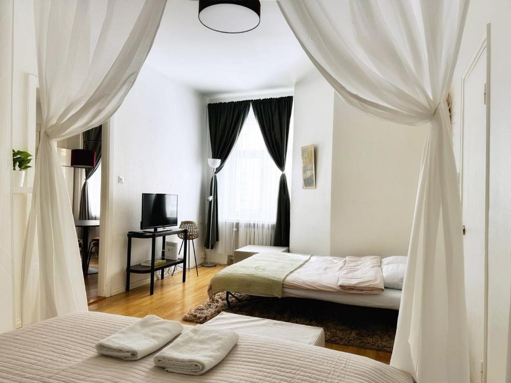 two beds in a room with white walls and curtains at 1BR Demure Design & Urban Living in Kamppi in Helsinki