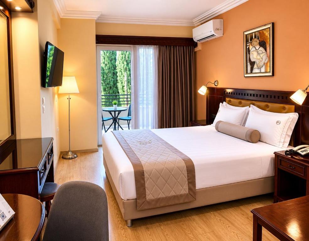 a hotel room with a large bed and a television at Hotel Pella in Giannitsa