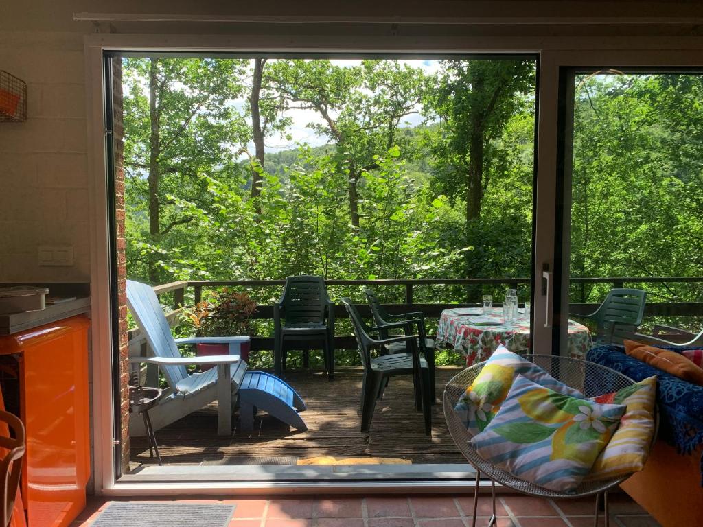 an open door to a patio with a table and chairs at Chalet cosy - terrasse et détente, escapade nature au Bonsoy in Waulsort