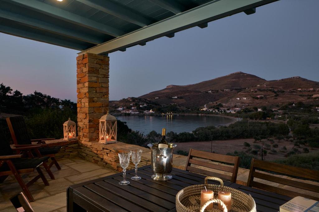 a table with wine glasses and a view of the water at Sea Breeze in Otziás