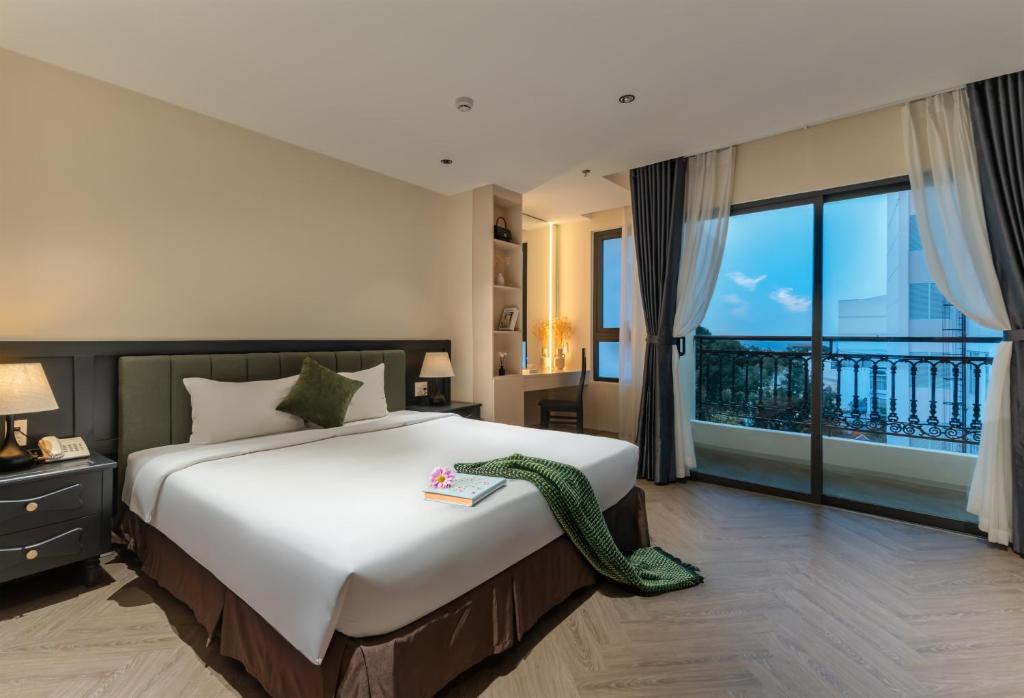 a bedroom with a large bed and a balcony at Jolia Nha Trang Hotel in Nha Trang