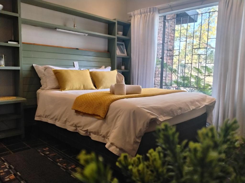 a bedroom with a bed and a window at Gorgeous Gecko Guesthouse in Modimolle
