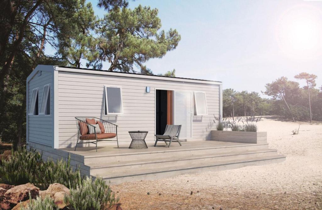 a tiny house with a deck on the beach at Camp Diekirch - Mobilehome Plus 4p in Gilsdorf
