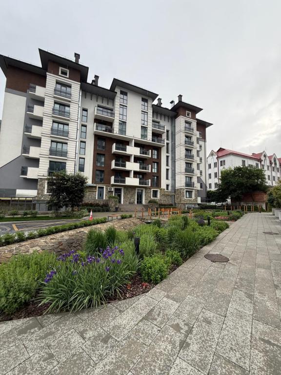 a row of tall apartment buildings with purple flowers at ''Панорама Карпат'' Апартаменти в чудовому місті Яремче in Yaremche