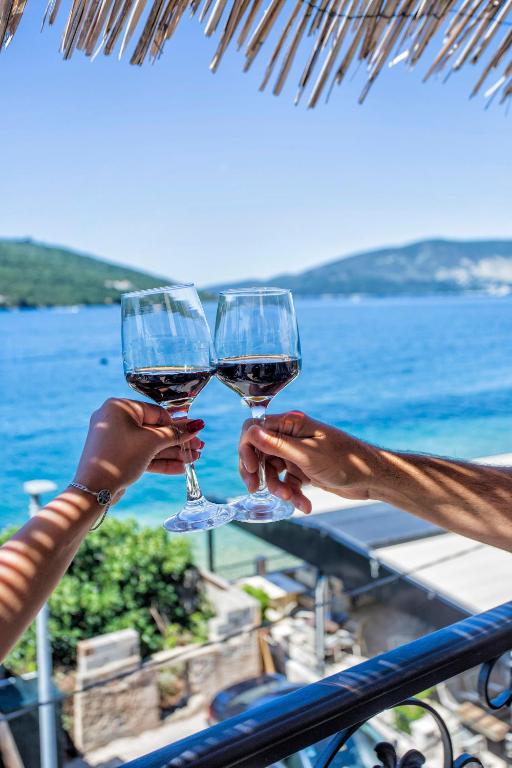 two people holding up glasses of wine at Apartment SM in Herceg-Novi