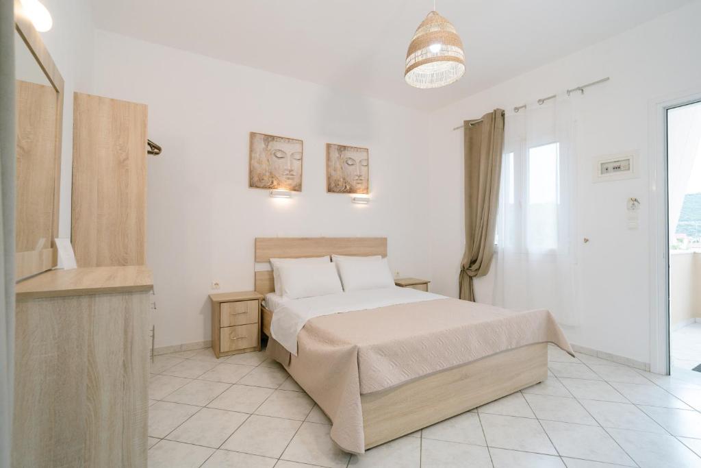 a white bedroom with a bed and a bathroom at Villa Elva in Ammoudia