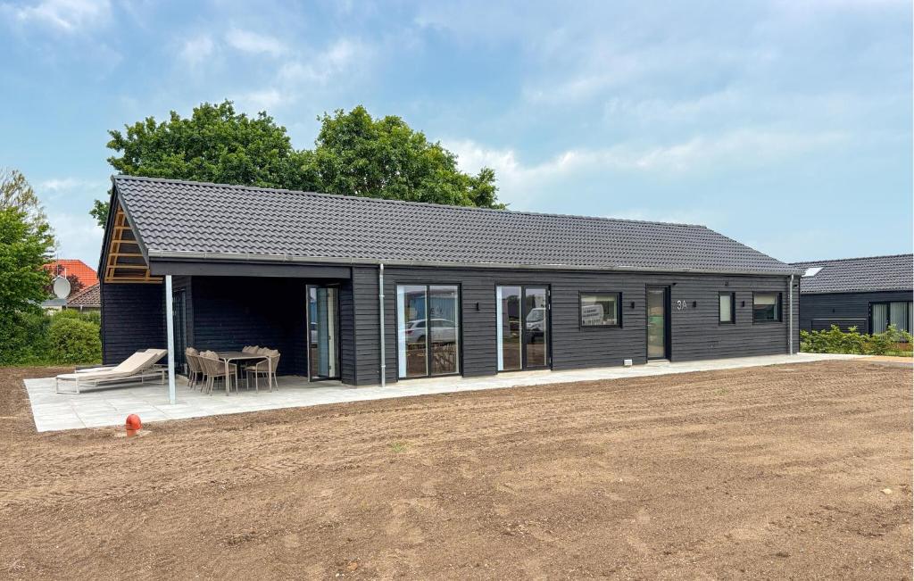a black shed with a patio and a house at 4 Bedroom Cozy Home In Haderslev in Haderslev