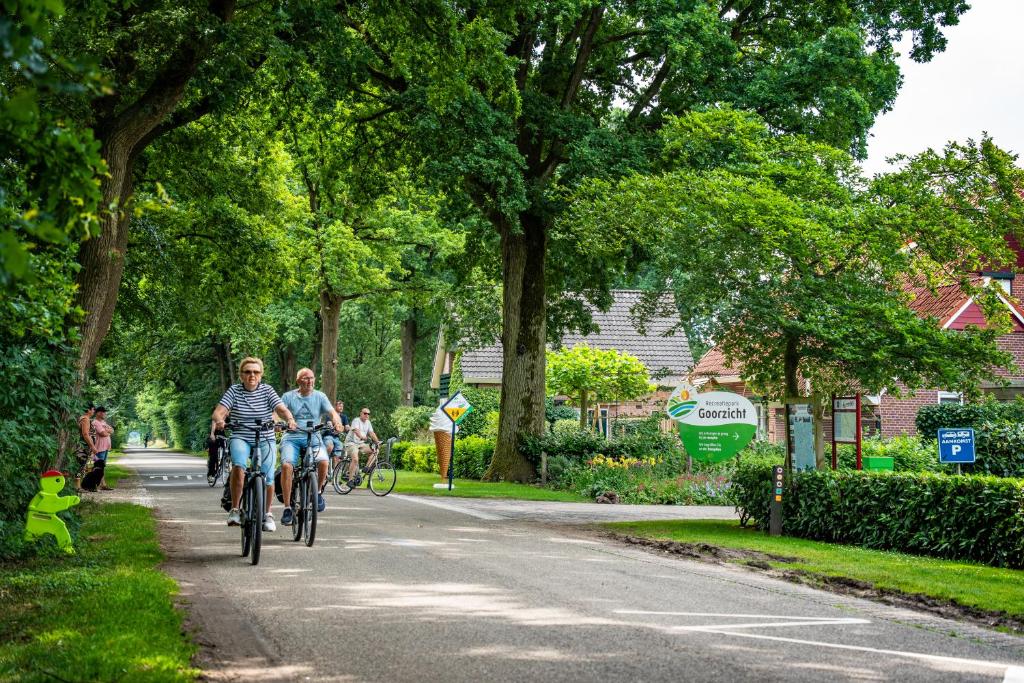 two people riding bikes down a street at Recreatiepark Goorzicht in Aalten