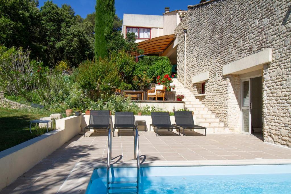 a patio with chairs and a swimming pool next to a building at Le Clos Des Chênes in Lagarde-Paréol