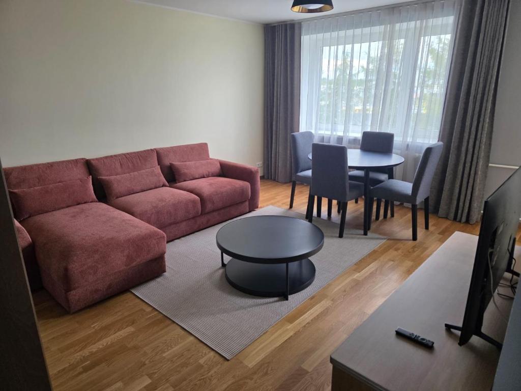 a living room with a red couch and a table at Külaliskorter Aardla tn 120 in Tartu