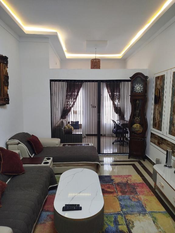 a living room with a couch and a clock at Mon Nid d'Or ABIDJAN CI in Abidjan