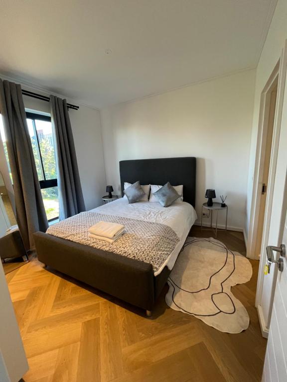 a bedroom with a large bed with a wooden floor at Silhouette Suite at Nine Palms in Cape Town