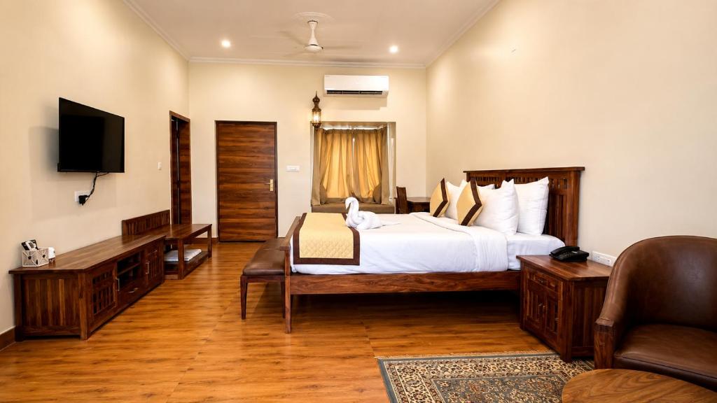 a hotel room with a bed and a television at Roop Garh Palace, Jaipur in Jaipur
