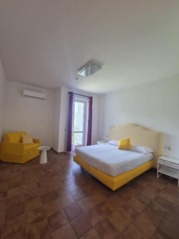 a bedroom with a large bed and a yellow chair at Ravello Sky & Sea in Ravello