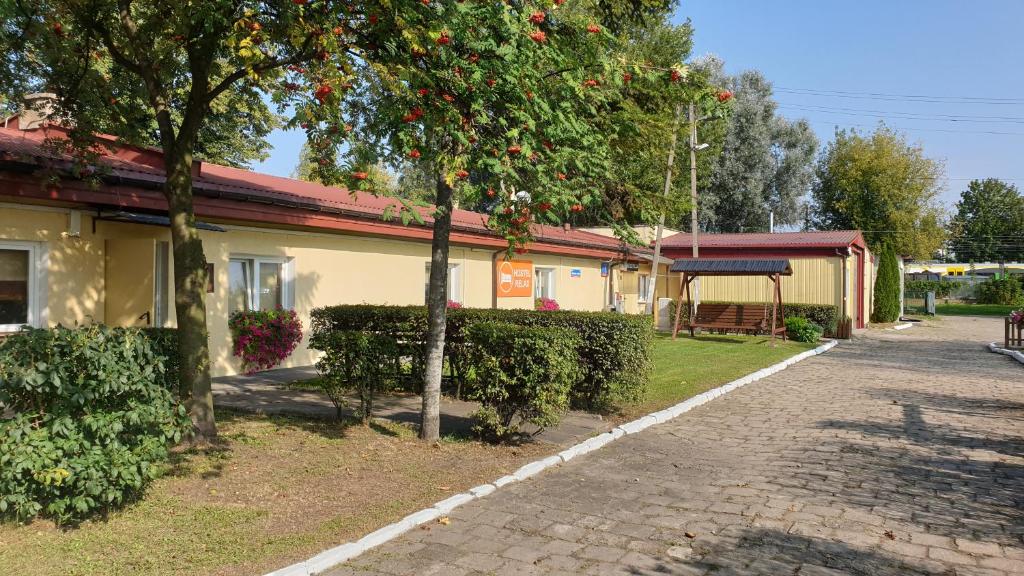 a building with a tree and a brick sidewalk at Hostel Relax in Warsaw