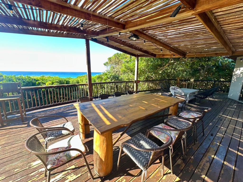 a wooden table and chairs on a deck at Kangela 14 in Ponta Malangane