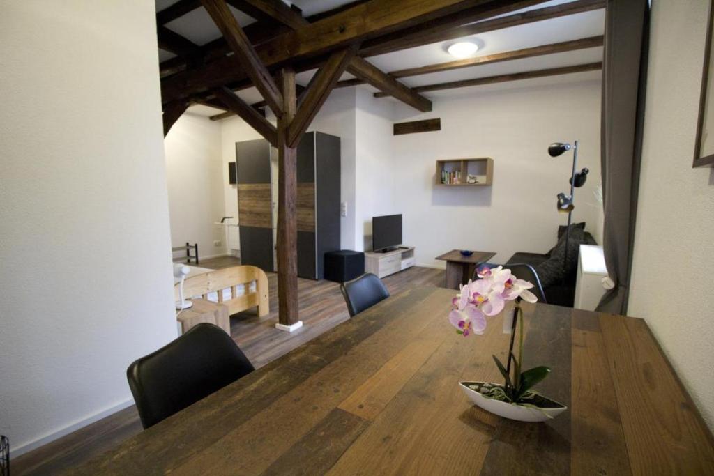 a dining room with a table with a vase of flowers at NEU! Wohnung Balkenzimmer in Alsfeld