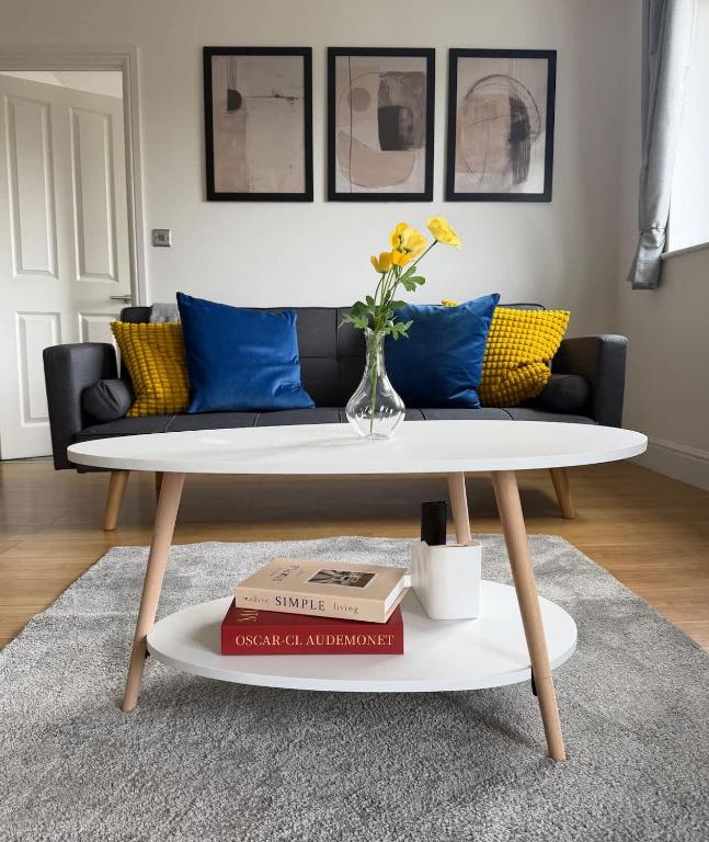 a coffee table with a vase of flowers on a table at Modern 2 Bed Flat, Free Parking, Central Hemel in Hemel Hempstead